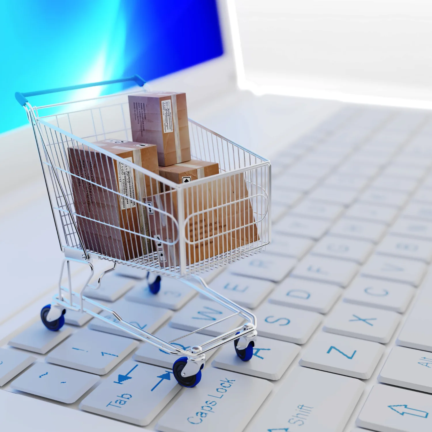 A miniature shopping trolley filled with parcels standing on a laptop keyboard